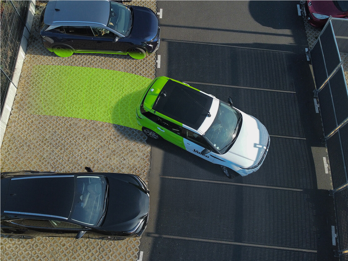 Vue aérienne d'un parking extérieur avec une voiture en train de se garer