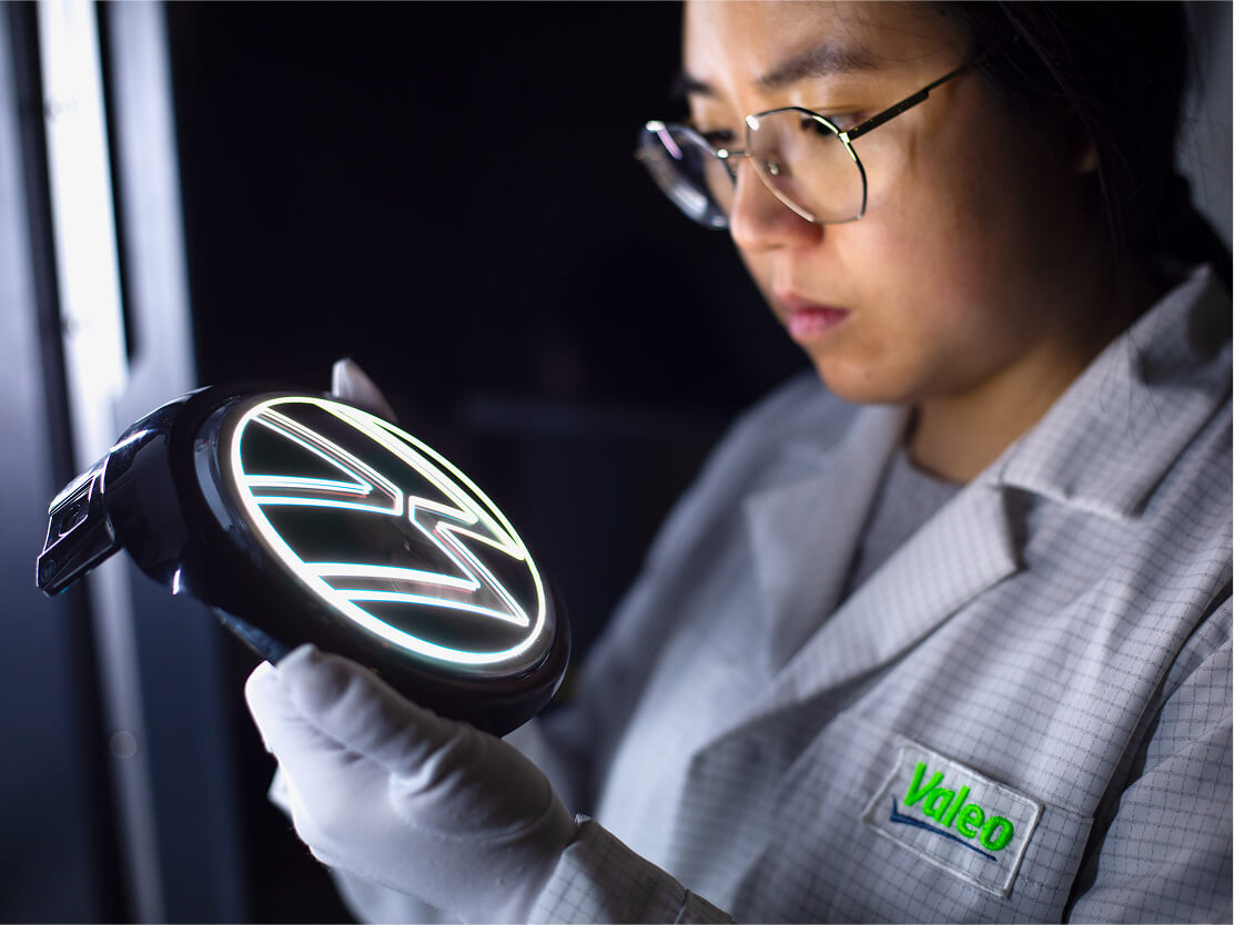 Une femme qu'inspecte le logo Volkswagen illuminé