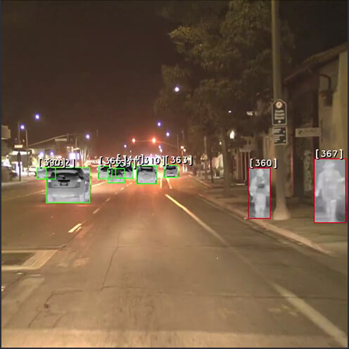 Vue d'une rue avec des voitures et personnes recréées par une camera thermique.
